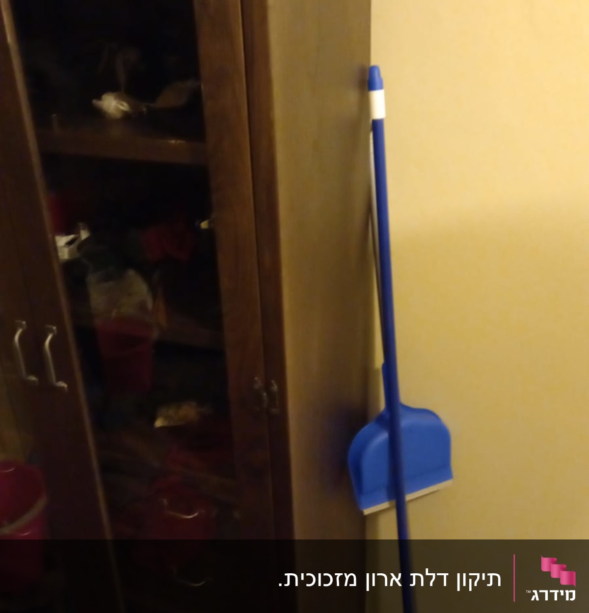 ארון עם דלתות זכוכית ומטאטא כחול